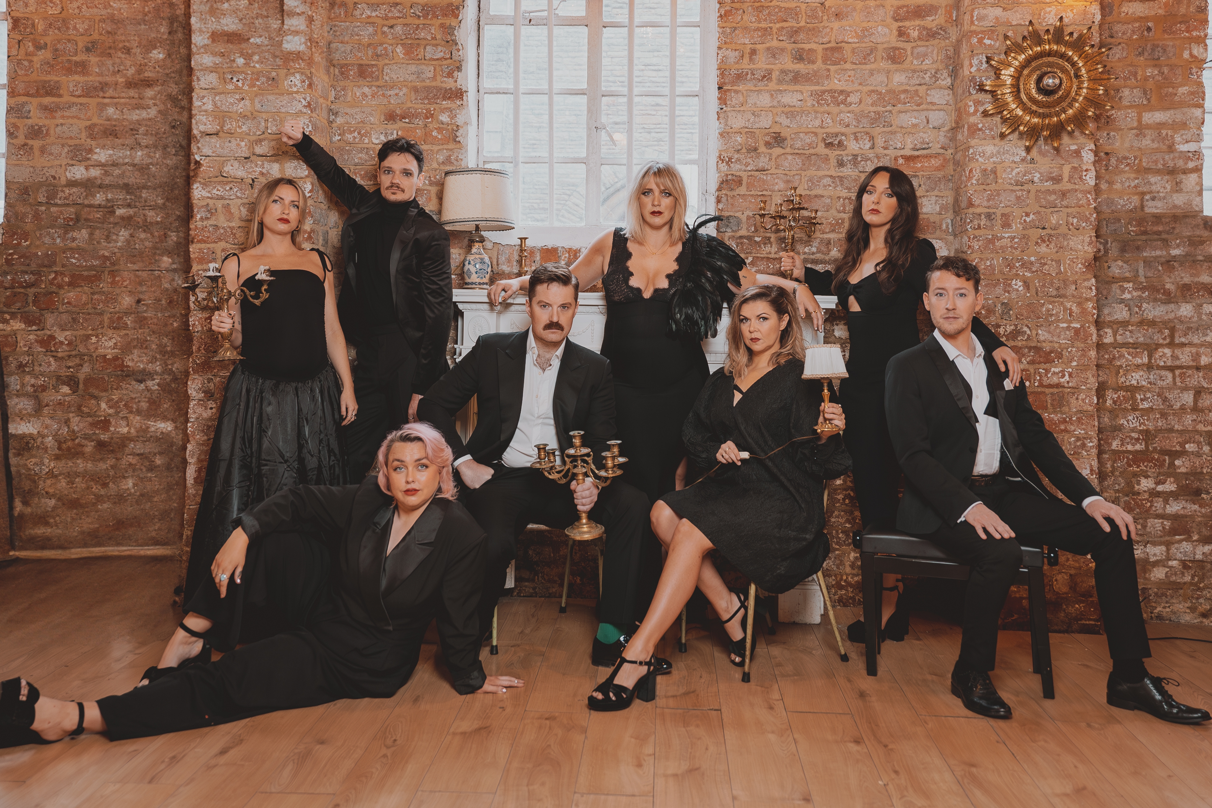 A picture of the Cabarela crew wearing black, with some holding lamps.