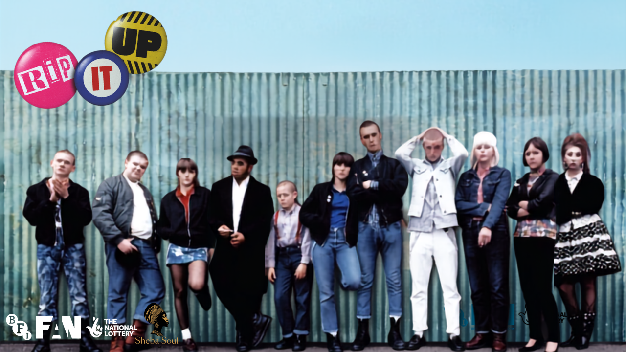 Gang of people standing in a line in front of a tall metal fence