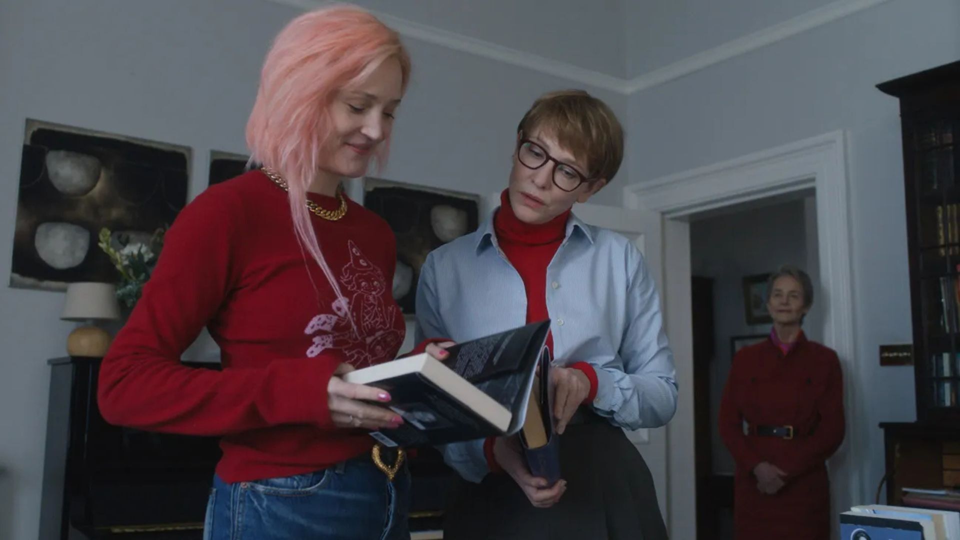 Two women in a house looking at a book