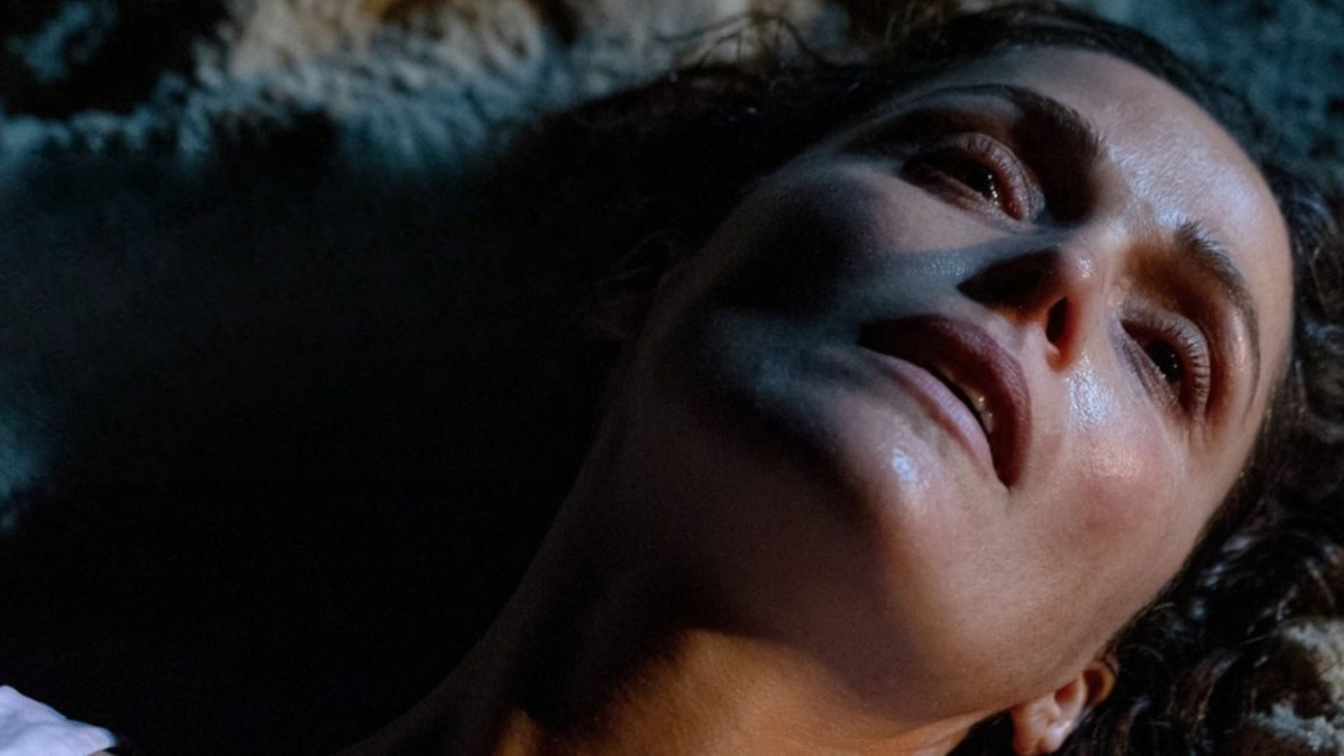 Close up of woman lying on her back looking worried / in pain