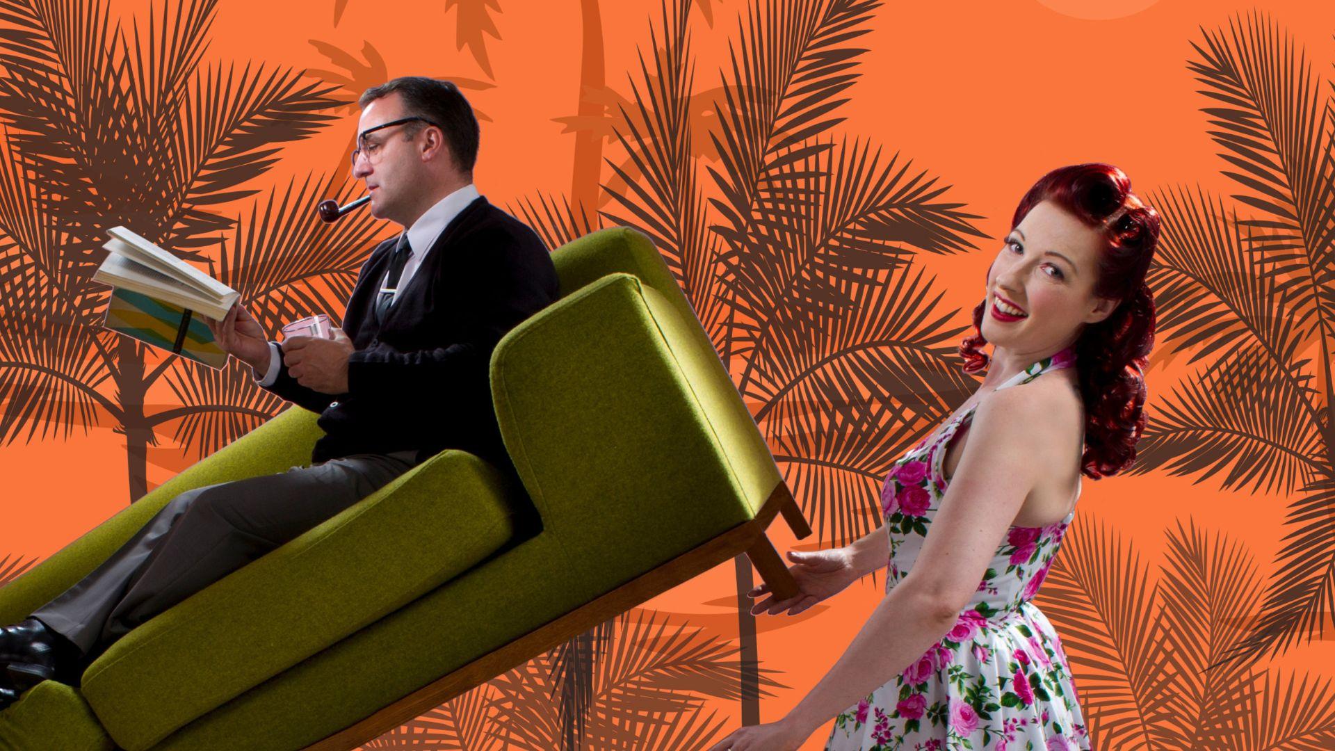 A woman in a floral dress vacuums while a man in a suit sits reading on a green couch tilted upward, set against an orange background with palm tree silhouettes.