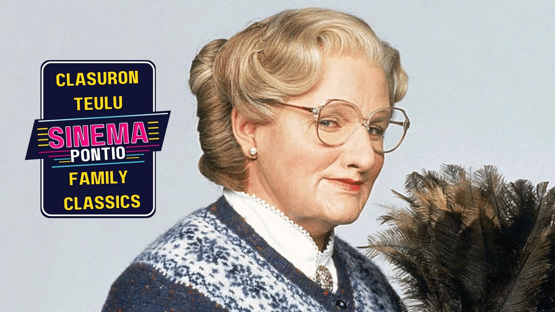 Mrs Doubtfire smiling at the camera holding a feather duster