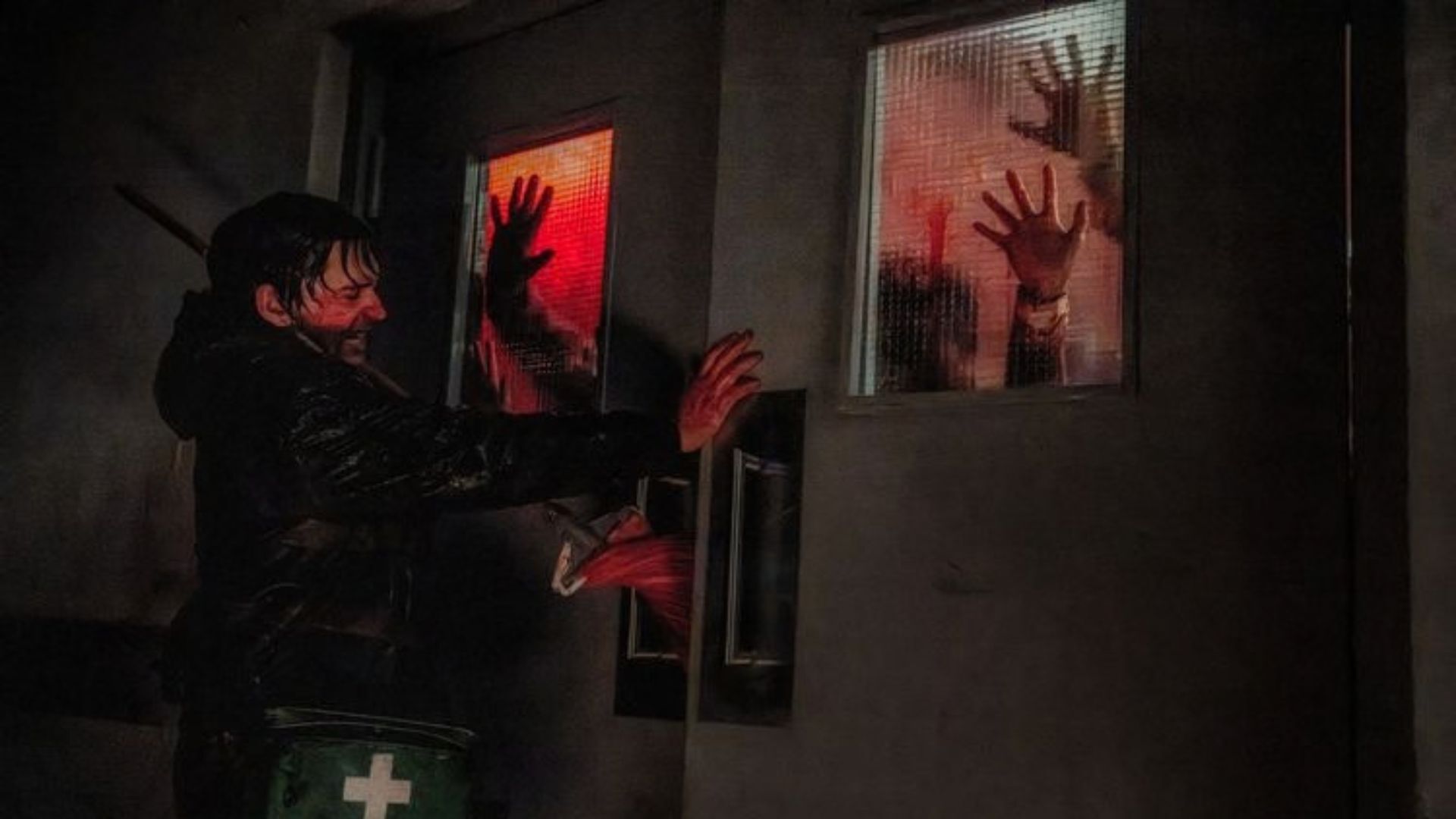 Man covered in blood trying to stop people from coming through the door