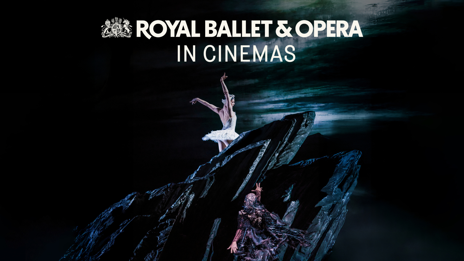 a female ballet dancer dressed in white poised on top of a rock