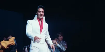 Elvis on stage wearing a white suit