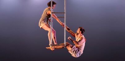 Man and woman doing aerial work with dark grey background