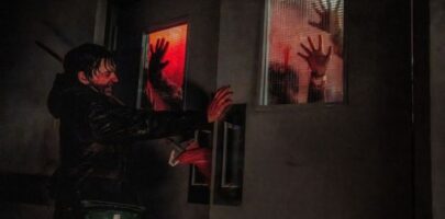 Man covered in blood trying to stop people from coming through the door