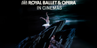 a female ballet dancer dressed in white poised on top of a rock