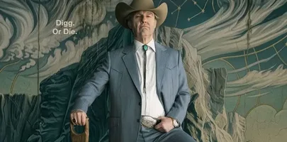 Man in a blue suit and cowboy hat holding a shovel