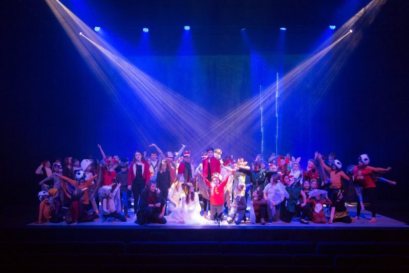 A group of people on a stage all wearing costumes