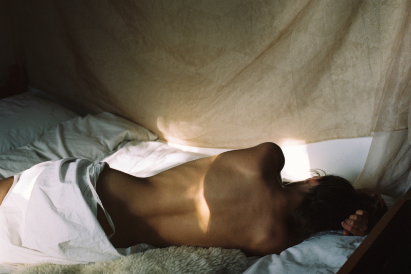 Woman lying on her side on a bed